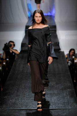 Model in black top and brown pants by Alix Hadley