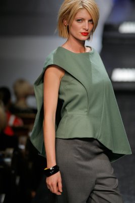Model wearing green top with grey skirt by Anna Arguello